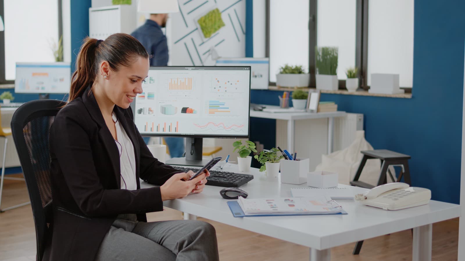 Freelancer reviewing spending on a phone and laptop